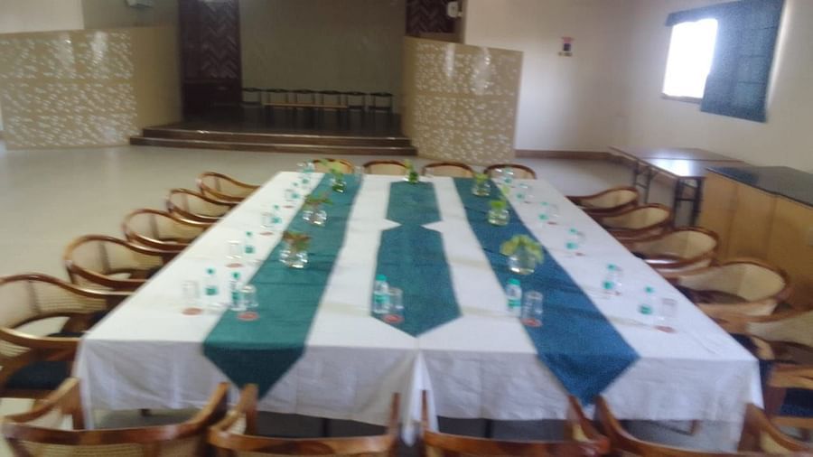 A large dining table set for a formal event with white, blue, and green runners - Lords Eco Inn Belagavi