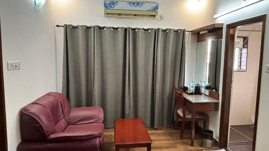 A well appointed living area with a sofa and a small desk provides a functional space for guests at Lords Midtown Suites.