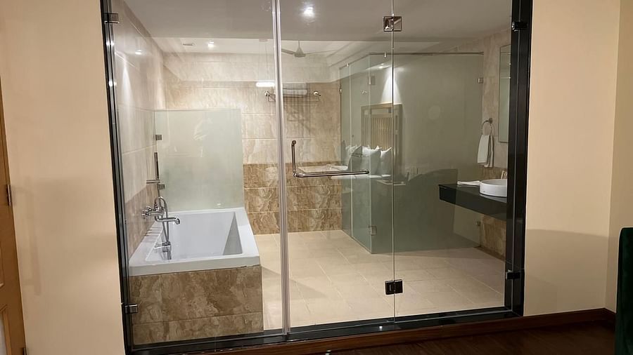 A view of a modern, furnished bathroom at MM Legacy in Kanchipuram, showcasing elegant fixtures and a glass window that allows natural light to illuminate the space.