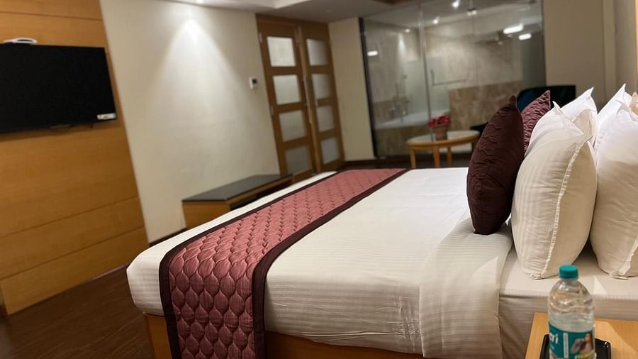 A cozy bedroom with a king-size bed, a reading chair, and a fireplace - MM Legacy, Kanchipuram.