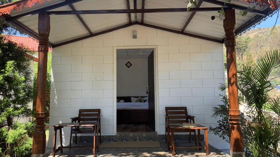 Neer Ganga | Chairs placed infront of a door in shade.