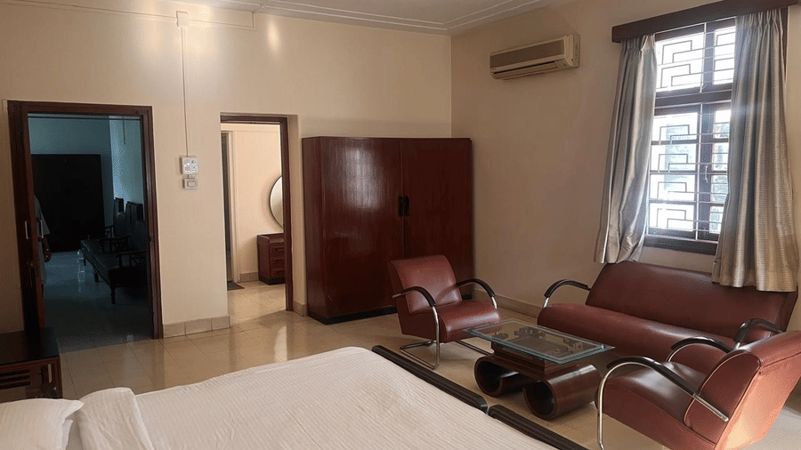 A perspective from the bed showing a cosy lounge area with leather chairs and a coffee table near the room's entrance | Trance Sunderban Resort