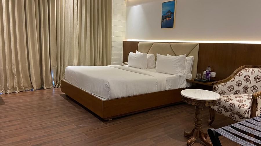 A bedrooom with double bed, round table, chair and warm lights
