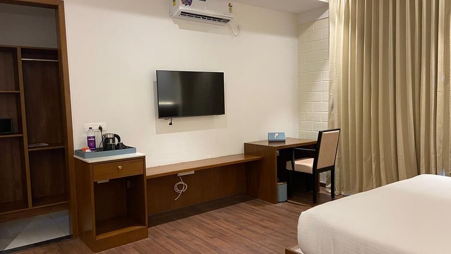 A room with double bed, desk  and TV.