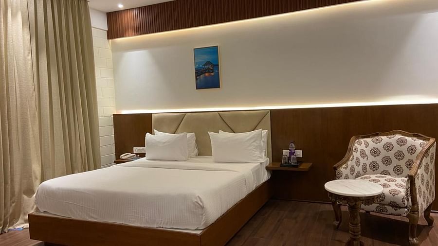A bedrooom with double bed, round table, chair and warm lights