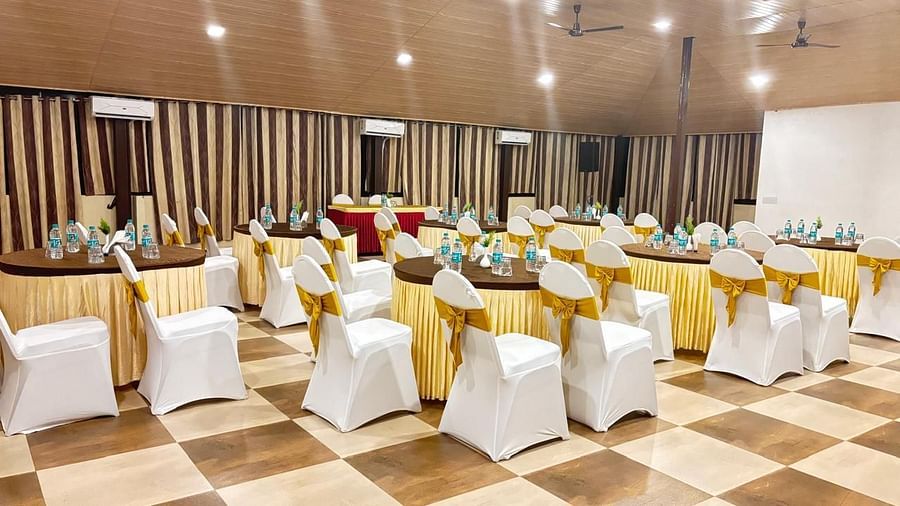 A banquet hall, highlighting the lighting and chairs facing a white screen | Ballroom | Woodstock Resorts, Coorg