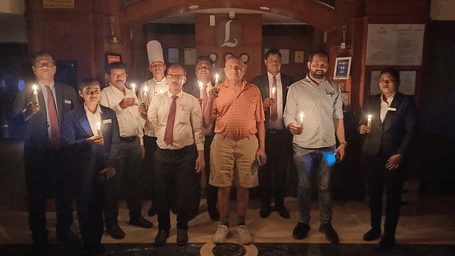 A large group of people holding  candles in a dark atmosphere.