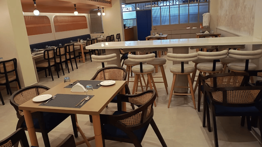 The Manorath restaurant at Lords Eco Inn, Belagavi featuring seating tables in various orientations, warm lighting and a relaxing dining  spot. 