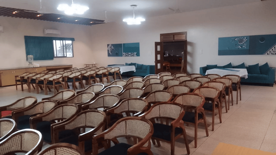A spacious event space with rows of empty chairs, likely set up for a conference or gathering - Lords Eco Inn Belagavi