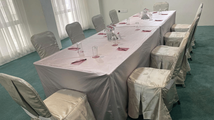 A table set for 10 with chairs and 2 windows