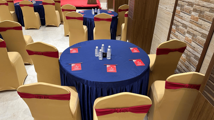 Multiple decorated round table and chairs featuring pamphlets and bottles at Shyanu Lords Eco Inn Airoli.