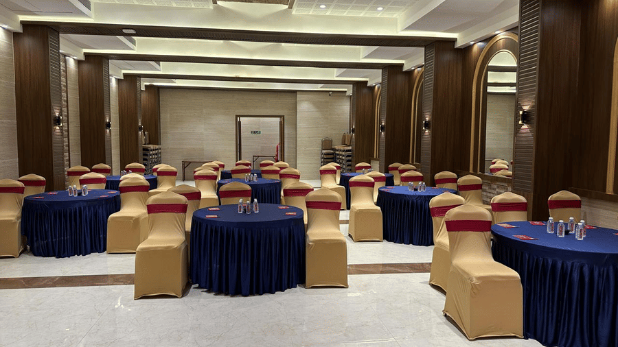 A spacious hall with decorated round tables and chairs at Shyanu Lords Eco Inn Airoli.