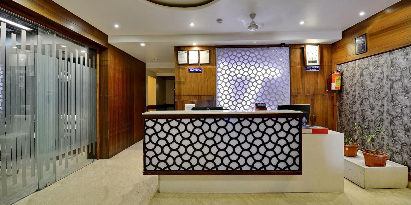 A modern hotel reception area with a stylish counter and warm lighting - Hotel Emerald, Chandigarh