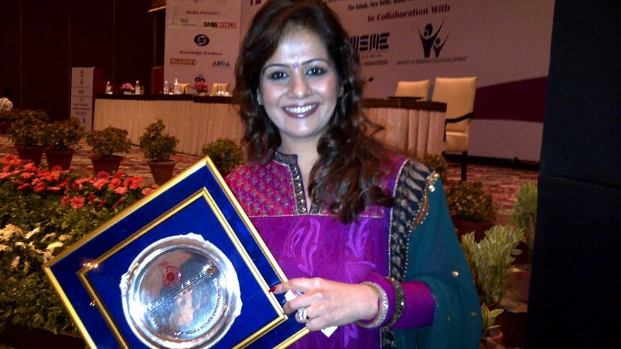 Kiran Bawa posing for a picture with an award - IOSIS Spa & Wellness