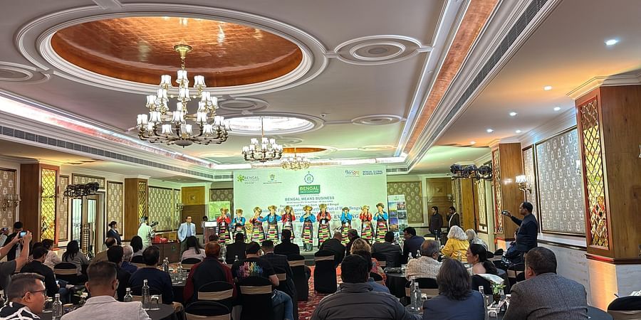 A cultural performance at the Bengal MICE Conclave, with traditional dancers on stage and a business audience in an elegant banquet hall.