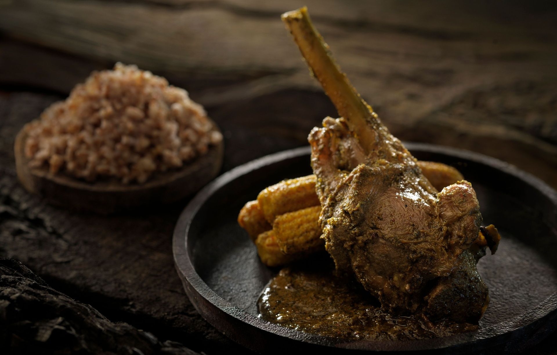 Roasted lamb shank with sauce, corn and rice.
