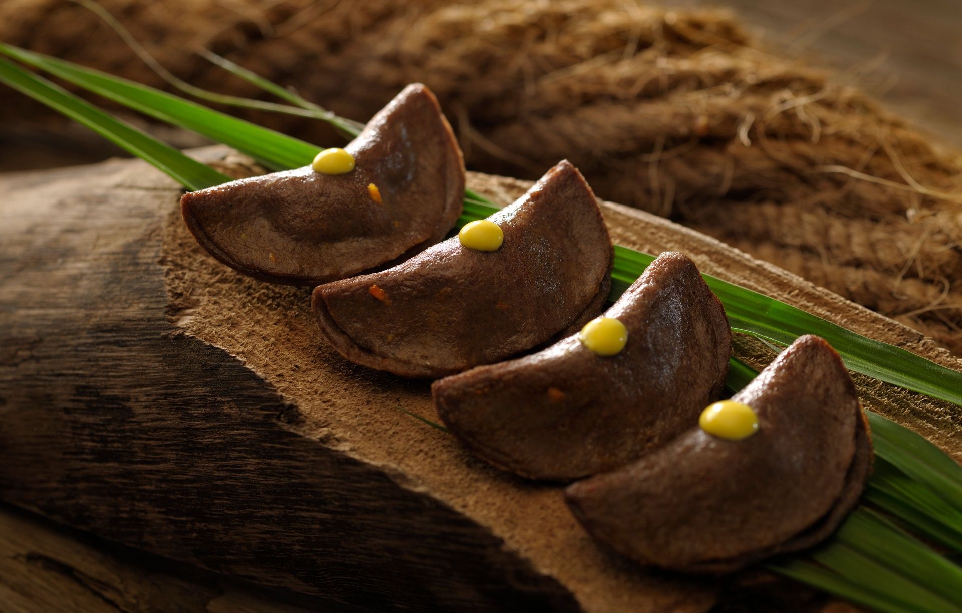 Four crescent-shaped dumplings with a yellow dot.