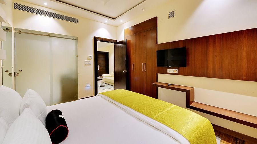 suite master bedroom with wooden wardrobe and an extended wall decor behind the tv.