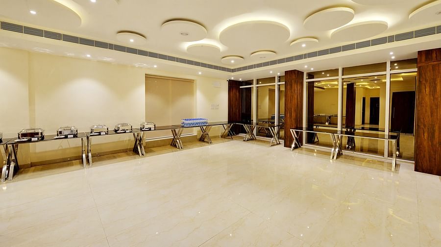      Minimalist banquet room with a polished floor, mirrored windows, and ceiling decor.