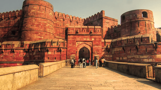 Red Fort in Agra featuring a long pathway leading to a big monumental structure.