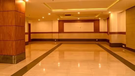 View of a spacious banquet hall with polished flooring and warm lighting - Max Hotel Prayagraj