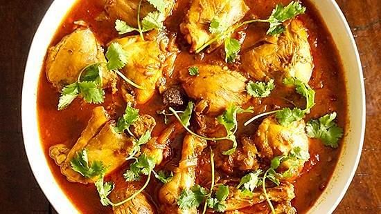 Spicy curry with pieces of meat and fresh coriander