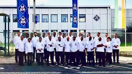 Staff posing for a group picture infront of the hotel.