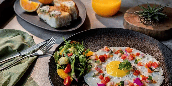 Plate of food with eggs and juice served on a table at Karma Chalets.