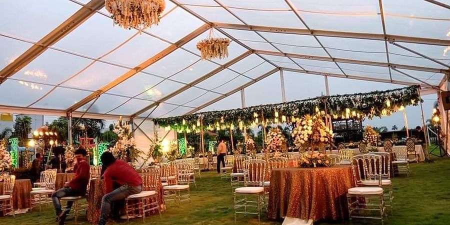 Grandly decorated event space of GK Hill View Resort featuring round seating tables, overhead shed, ample lighting and decorations.