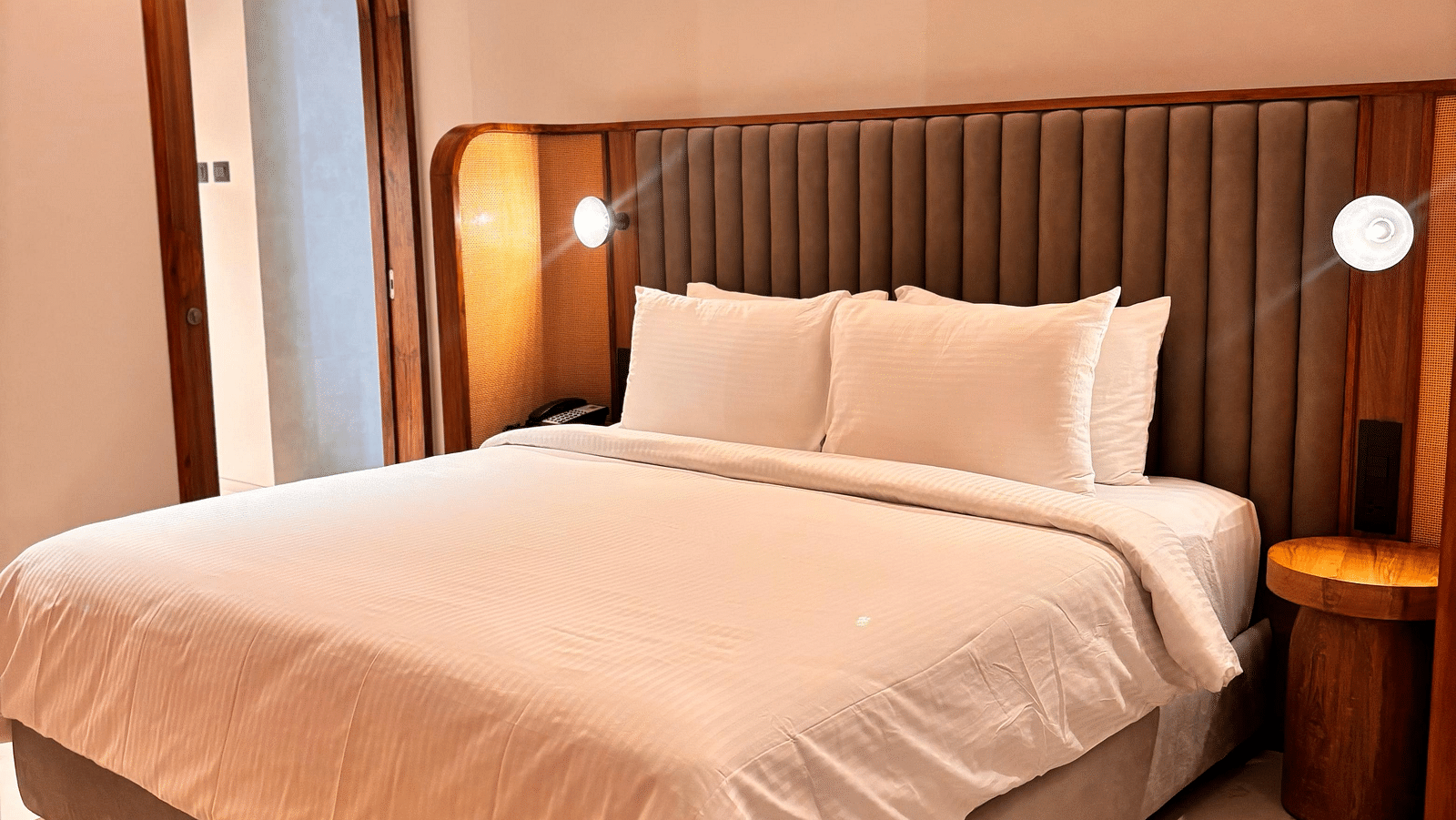 A bedroom at Swosti Premium Beach Resorts, Puri, with a made bed and a ceiling fan.