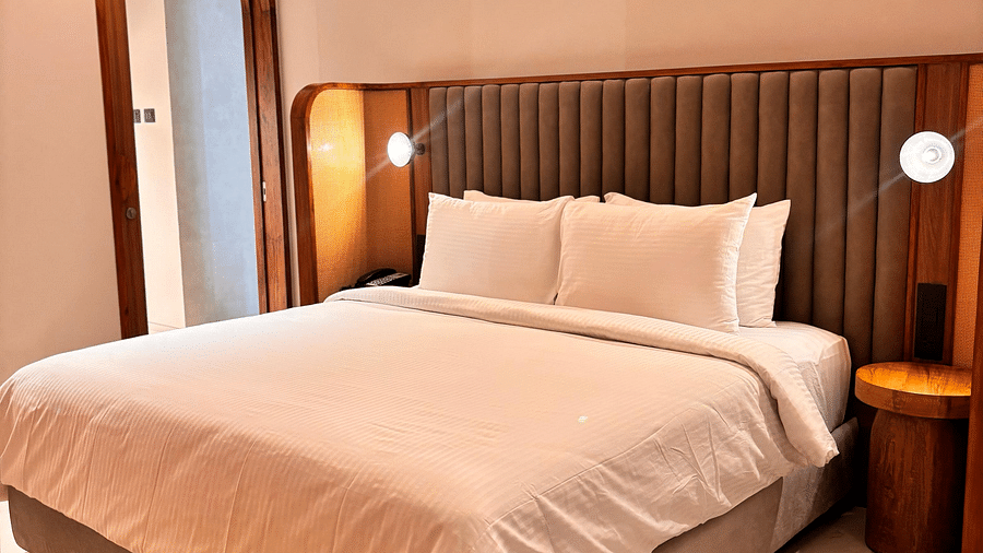 A bedroom at Swosti Premium Beach Resorts, Puri, with a made bed and a ceiling fan.