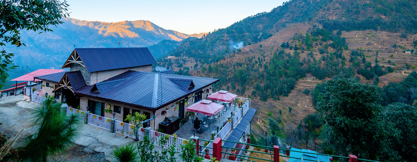 Resort with a garden and mountains in the background.