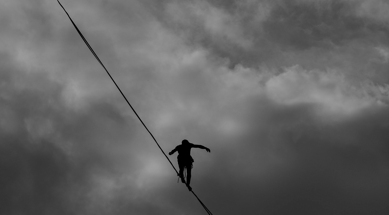 A person balancing on a rope suspended in mid-air.