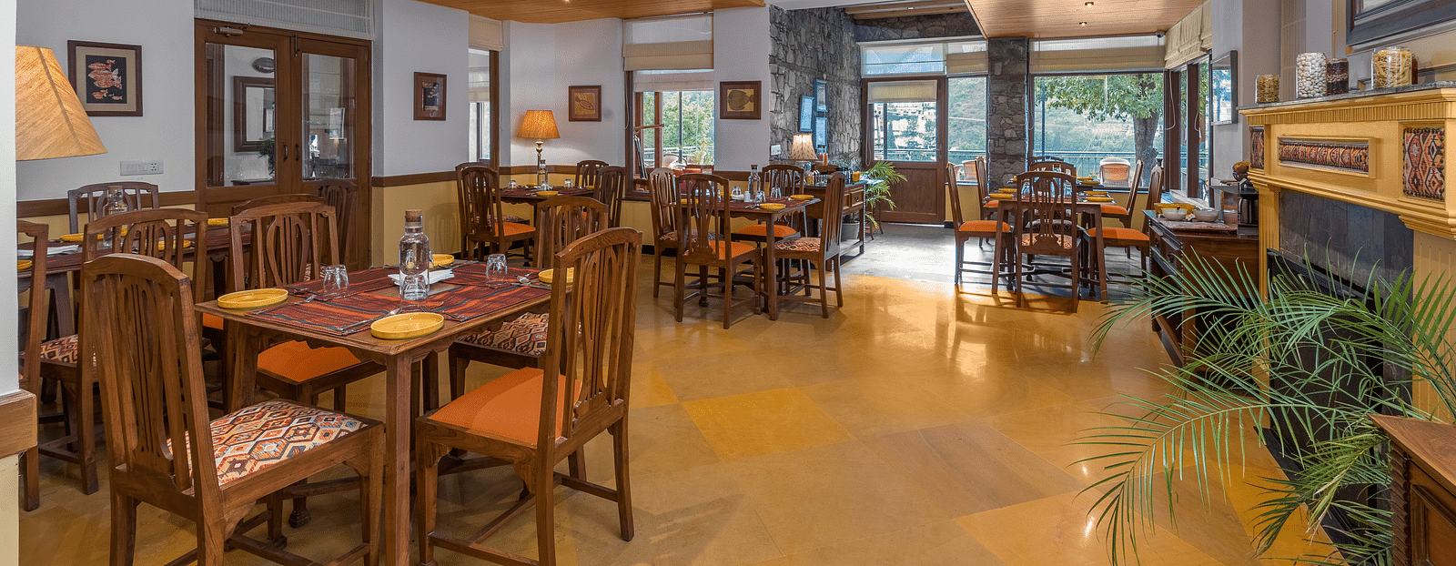 Indoor restaurant at Fishermen's Lodge, Bhimtal, featuring stylish wooden furnishings and a warm, inviting atmosphere.