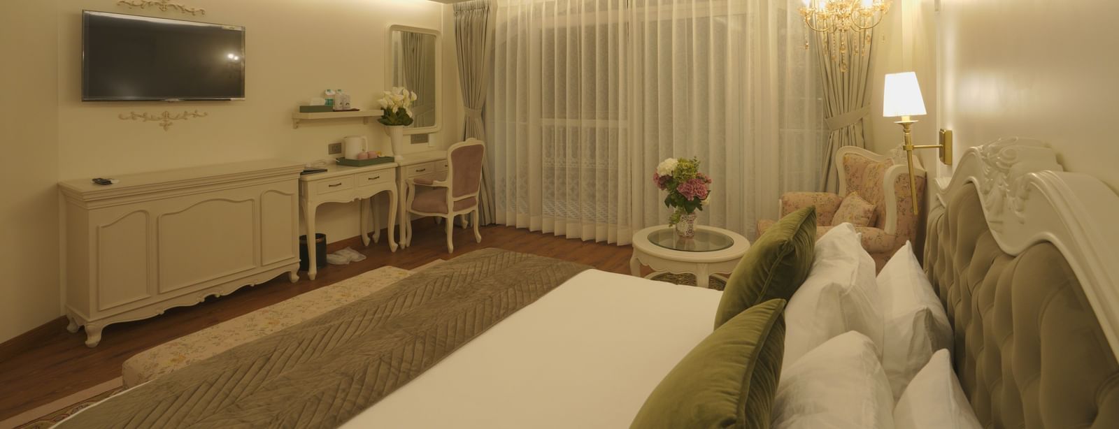 Elegant bedroom with a ceiling fan, muted lighting, and tasteful furnishings - Mayfair Cafe & Suites, Dalhousie