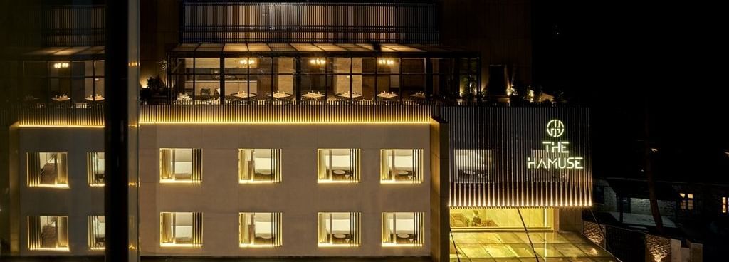 The Hamuse Hotel, Kodaikanal facade view with a view of rooms and the rooftop dining area.