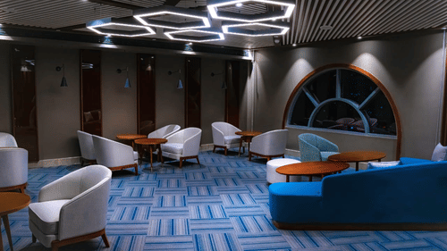 A seating cluster in our restaurant featuring round wooden tables, cushioned chairs, and bright ceiling fixtures - Serene Sarovar Premiere Hargeisa