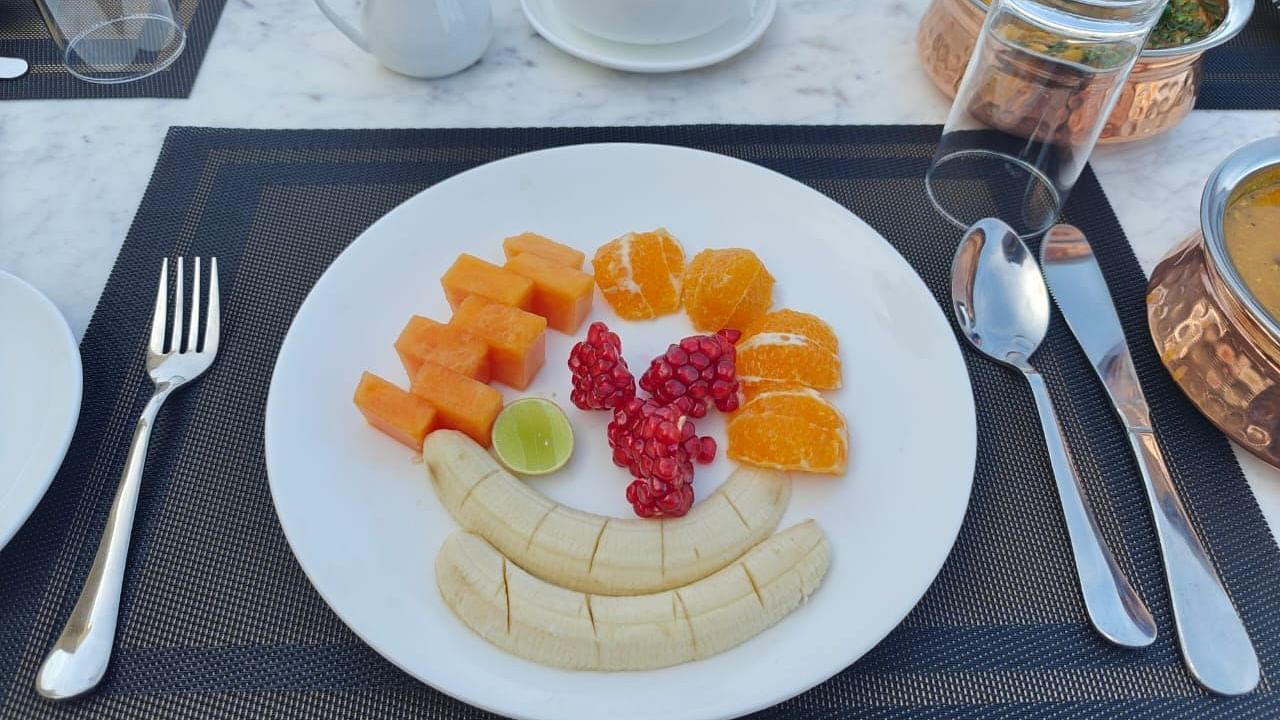A plate with freshly cut fruits and cutlery on the side at KURJA Jawai.