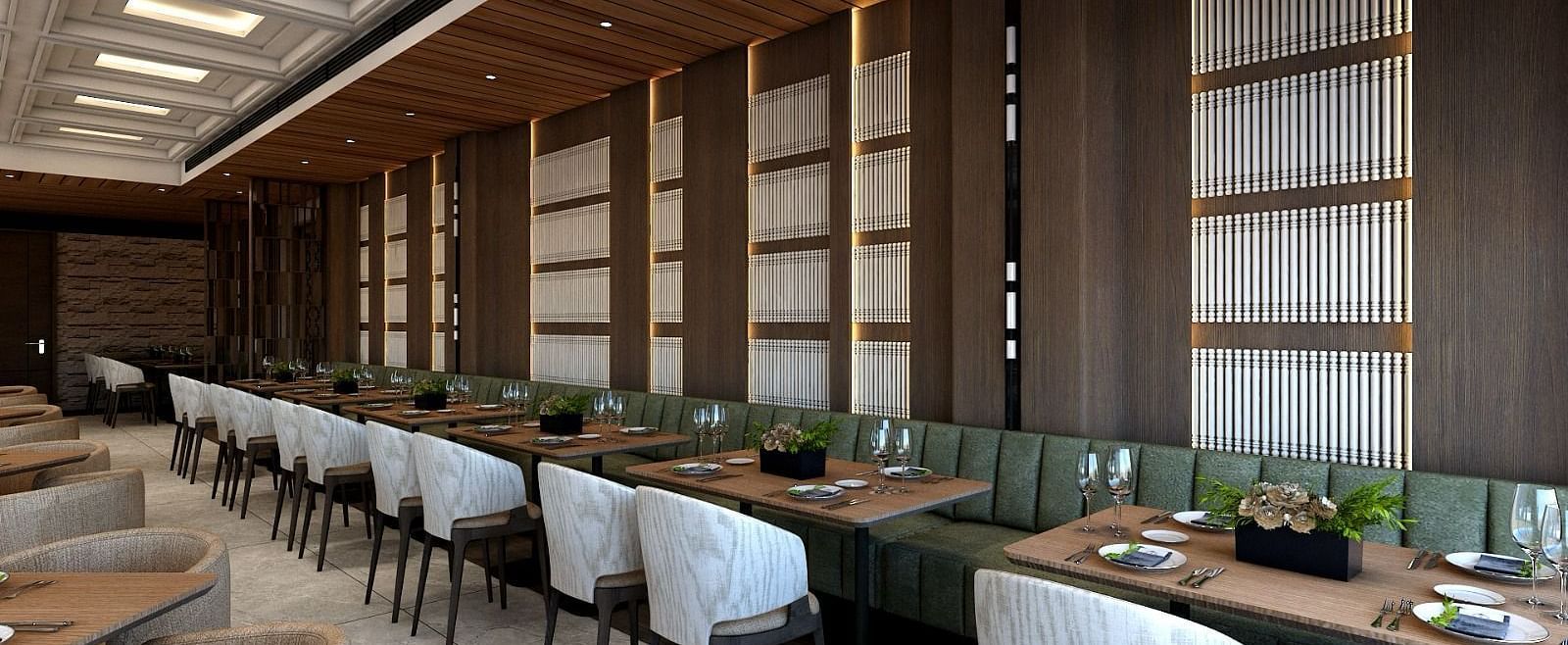 A long green coloured sofa lined with several dining tables along with grey coloured cushioned chairs - Namaste Corbett