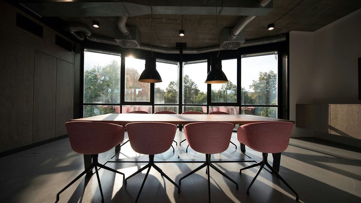 an image of a boardroom with a long table and multiple chairs
