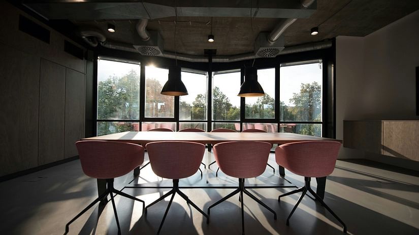 an image of a boardroom with a long table and multiple chairs