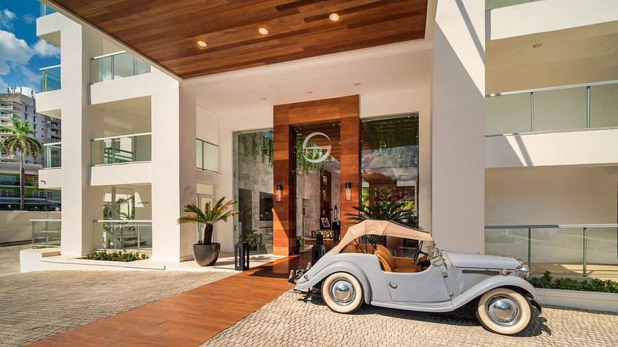 An image of hotel entrance with a vintage car parked in front of it - S Hotel Montego Bay, Jamaica