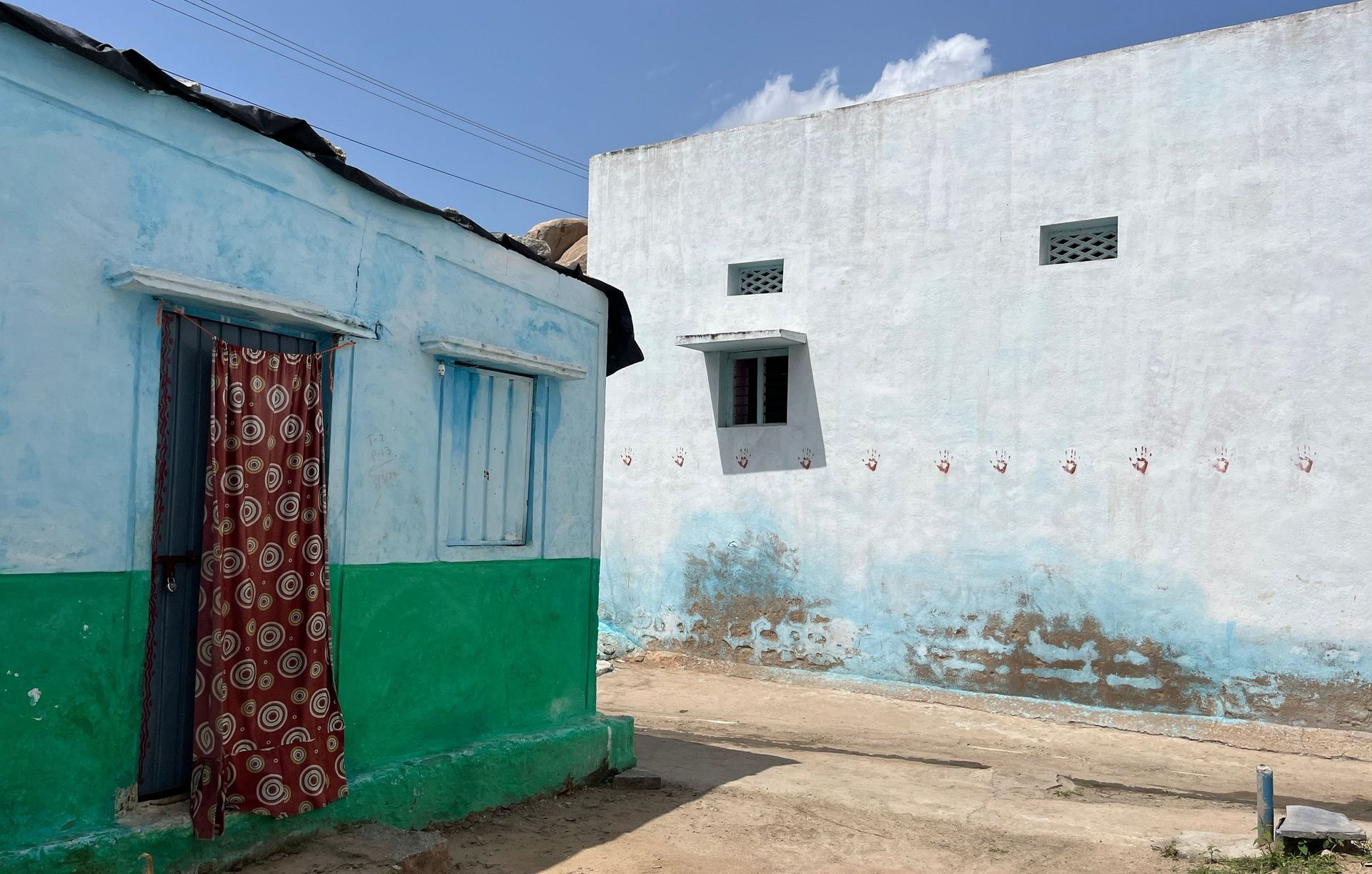 Anegundi village homes with traditional handprint decor.