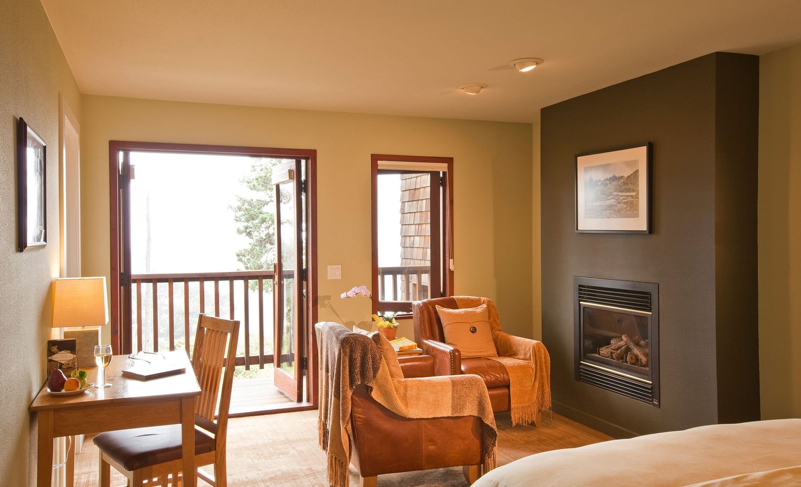 A spacious, elegant hotel room with large windows showcasing beautiful greenery outside, offering a tranquil and inviting atmosphere - Brewery Gulch Inn & Spa