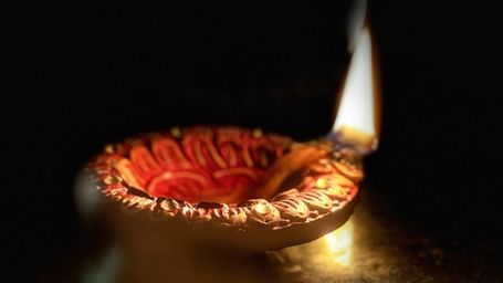 A close up of a lit diya used for many celebrations, including Karthigai Deepam.