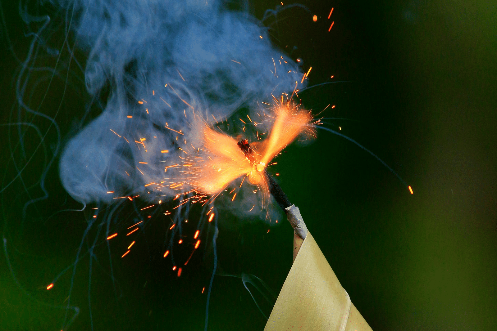 A top view of a lit cracker with smoking coming out that is kept in a banana leaf.