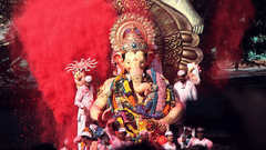ganapati idol with powdered colours in background