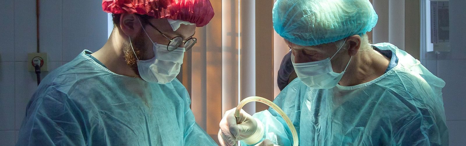 Two surgeons performing surgery inside a surgery room.