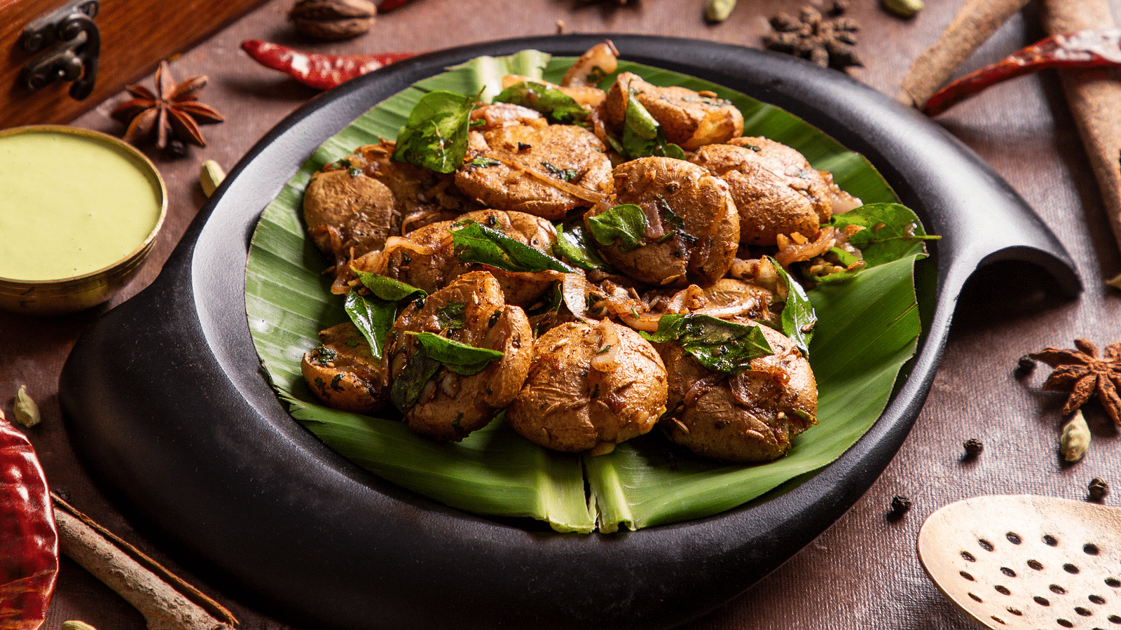 Exotic Indian spices and food served in a modern black dish. | Kamats India