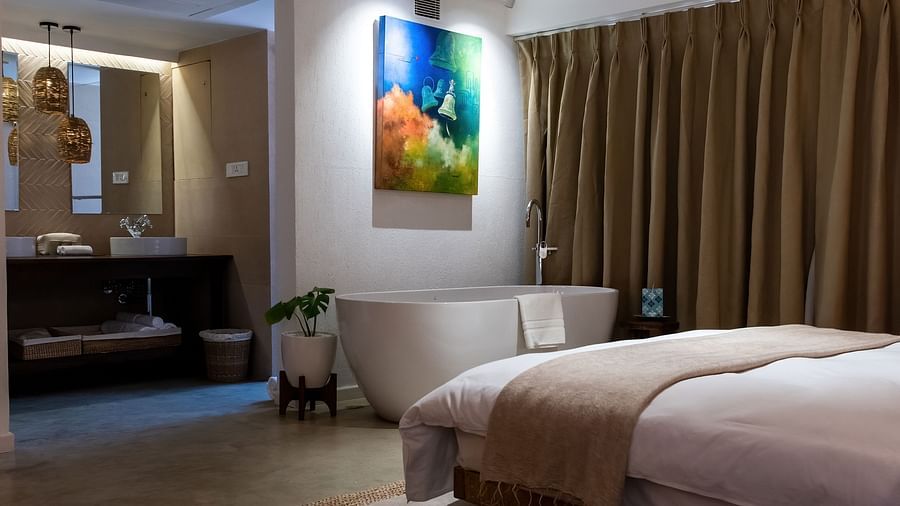 The Nepali Suite with bed, Wall hangings, and a bath tub - The Nanee